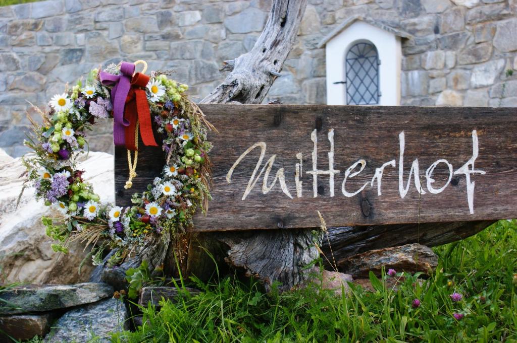 Blumengeschmücktes Holzschild am Mitterhof
